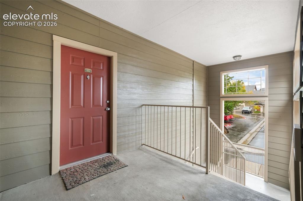 Image 6 of 50: Covered entryway featuring horizontal lap siding, a solid-panel door, and a