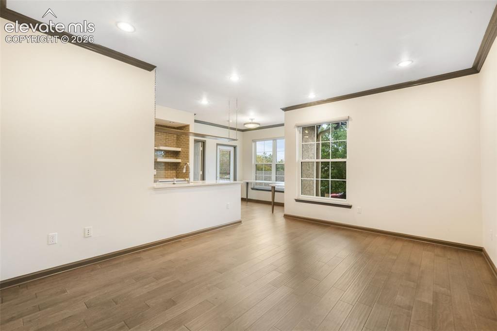 Image 7 of 50: Open-concept interior featuring wood-finish flooring, recessed lighting, cr