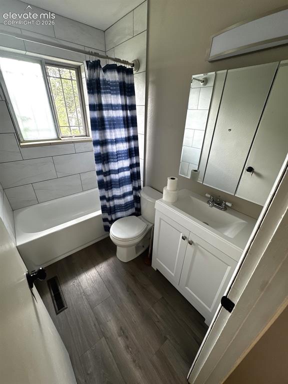 Image 6 of 14: White vanity with a rectangular sink, wood-finish flooring, white subway ti