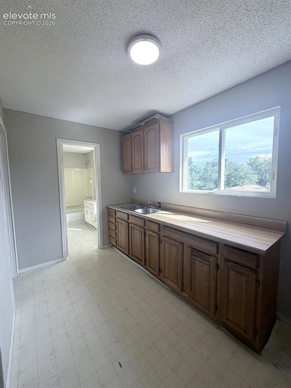 Image 9 of 14: Wood-finish cabinetry with a double basin stainless steel sink and laminate
