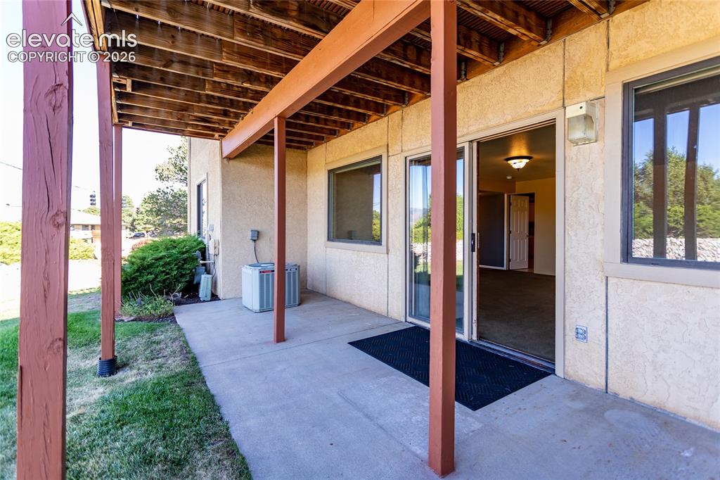 Image 15 of 29: Walk out basement with extensive concrete patio with large grassy area, vie