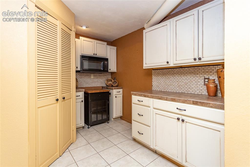Image 27 of 29: Basement kitchen area is full sized, built in microwave, sink, coffee count