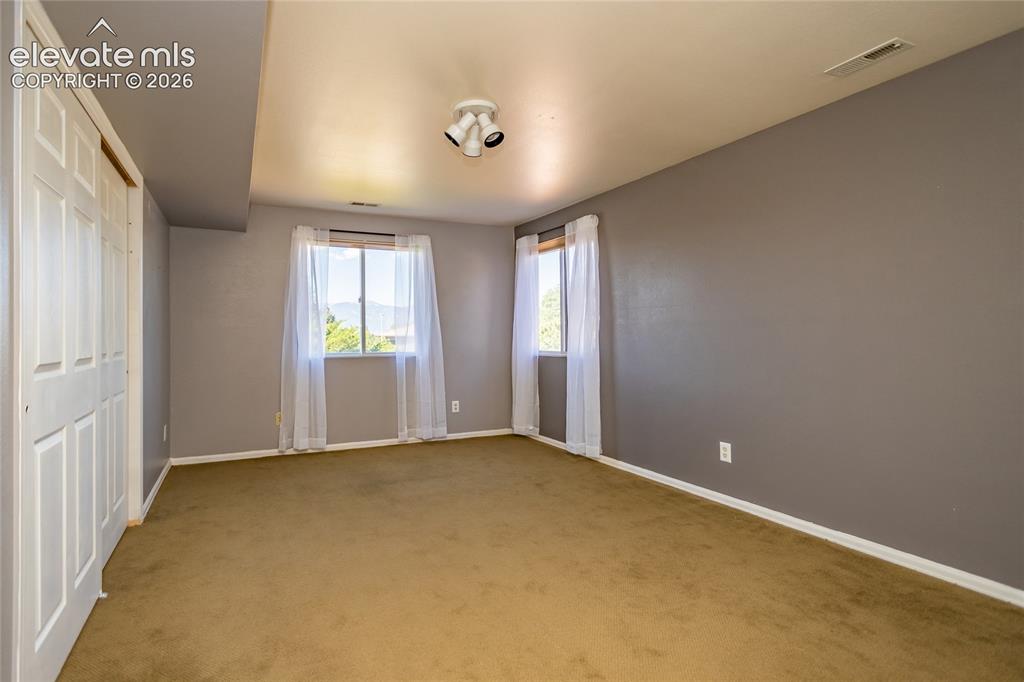 Image 29 of 29: Carpeted flooring, dual windows, track lighting fixture, bi-fold closet doo