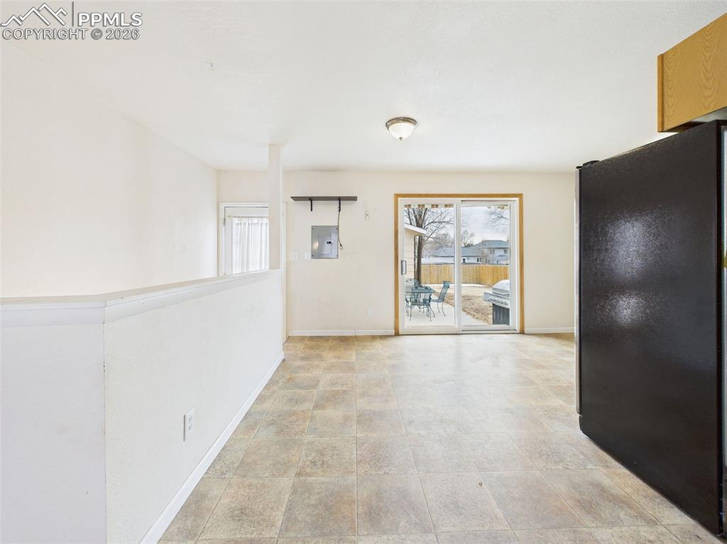 Image 14 of 50: Versatile space with durable tile flooring, backyard views, and adjacent ac