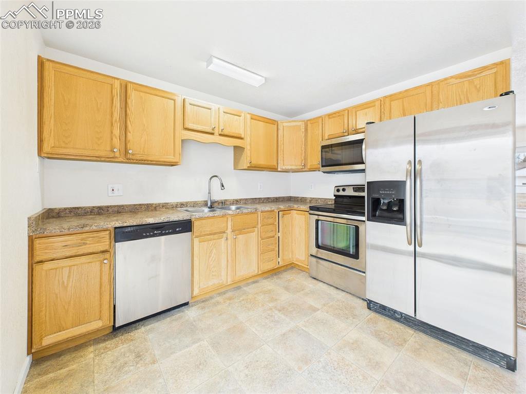 Image 17 of 50: Wood cabinetry, ample counter space, and stainless steel appliances provide