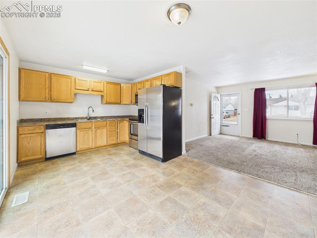 Image 18 of 50: A wide-angle perspective showing the open kitchen flowing directly into the
