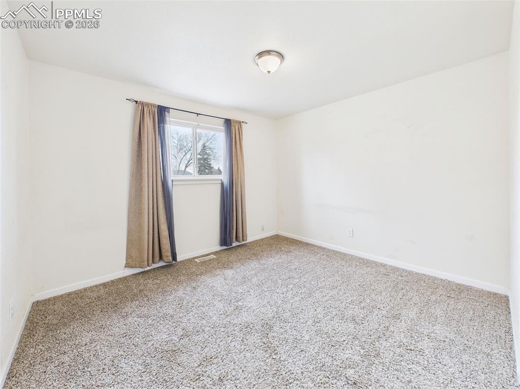 Image 19 of 50: Bedroom 1 Blank-slate simplicity with closet access and adjacent hallway vi