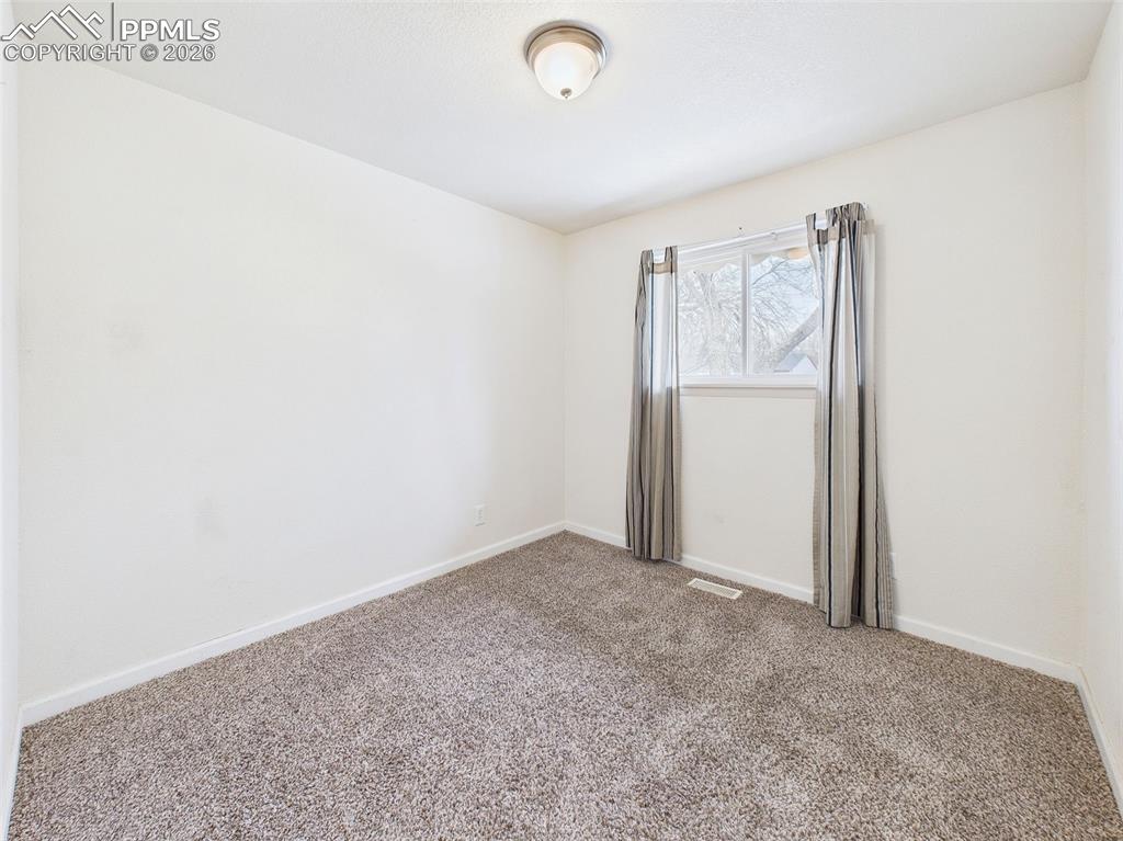 Image 23 of 50: Bedroom 3 A clean, roomy layout with double-door closets and natural light—