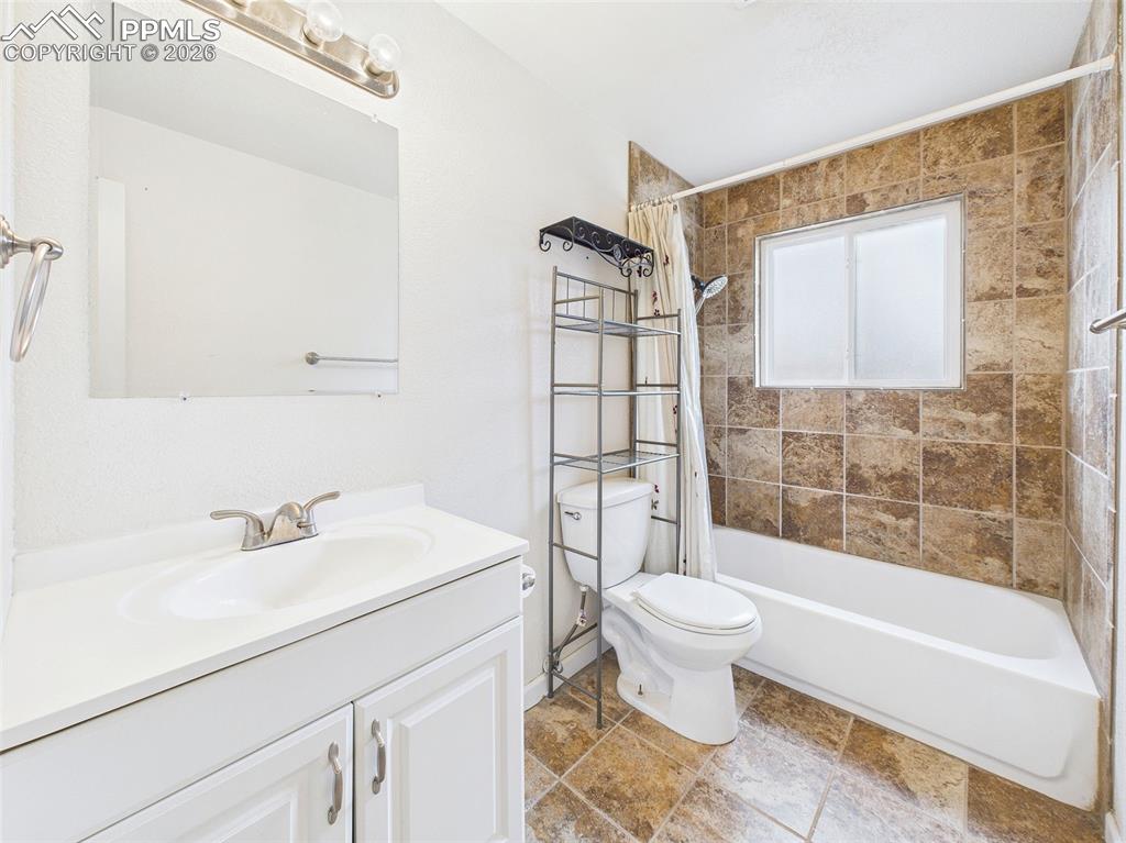 Image 25 of 50: Updated bath with tile surround and updated vanity