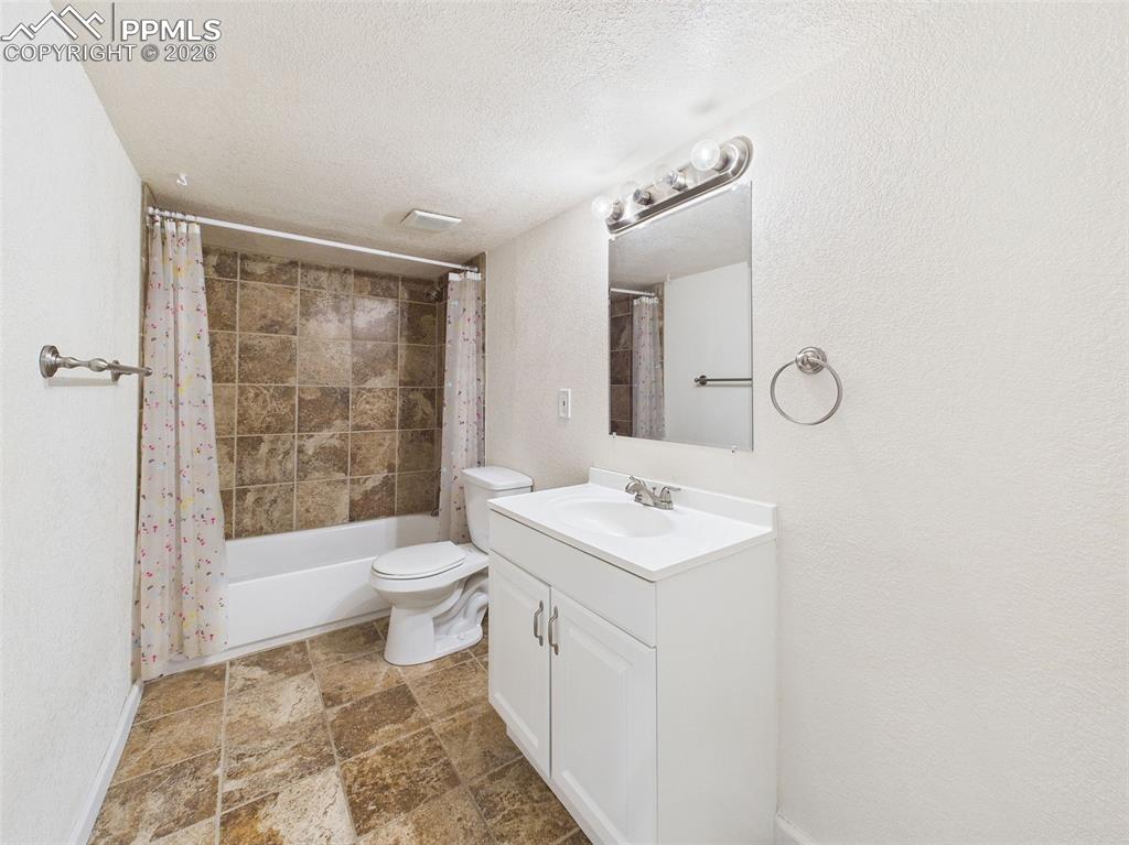 Image 38 of 50: A full lower-level bath with neutral finishes, tiled shower surround, and u