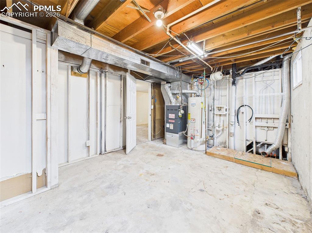 Image 40 of 50: Concrete floors, storage cabinetry, and exposed ceiling make this unfinishe