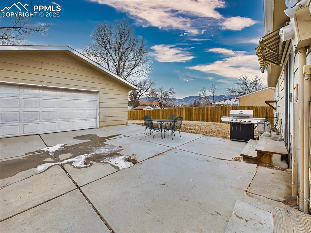Image 45 of 50: Enjoy mountain views from this large concrete patio, ideal for hosting barb