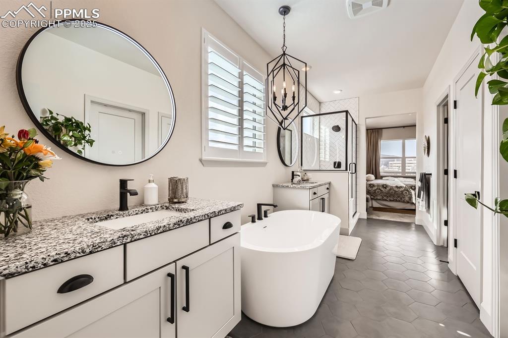 Image 14 of 28: Bathroom featuring tile patterned floors, separate shower and tub, a chande