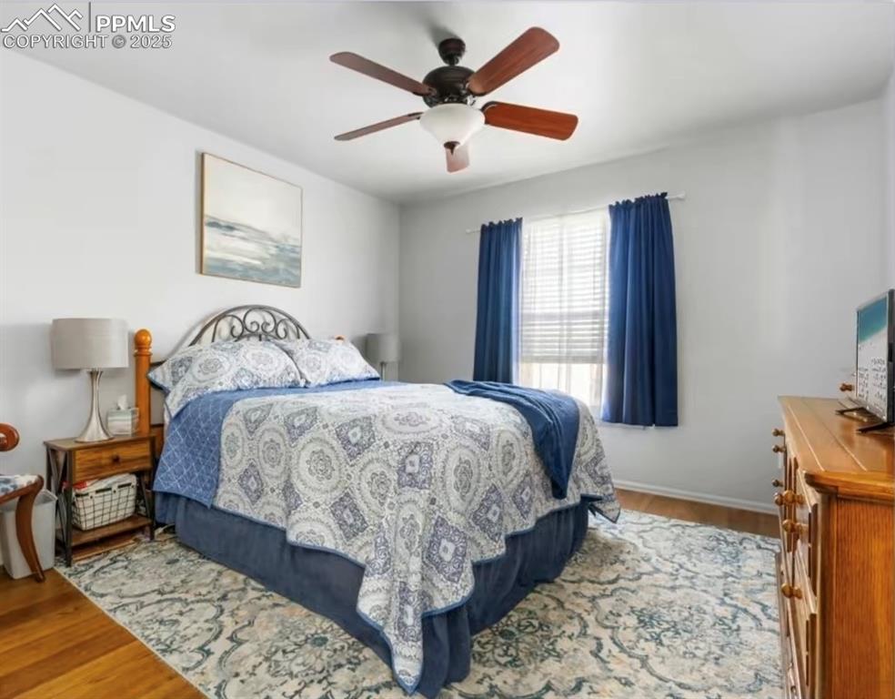 Image 5 of 9: Bedroom featuring wood finished floors and a ceiling fan