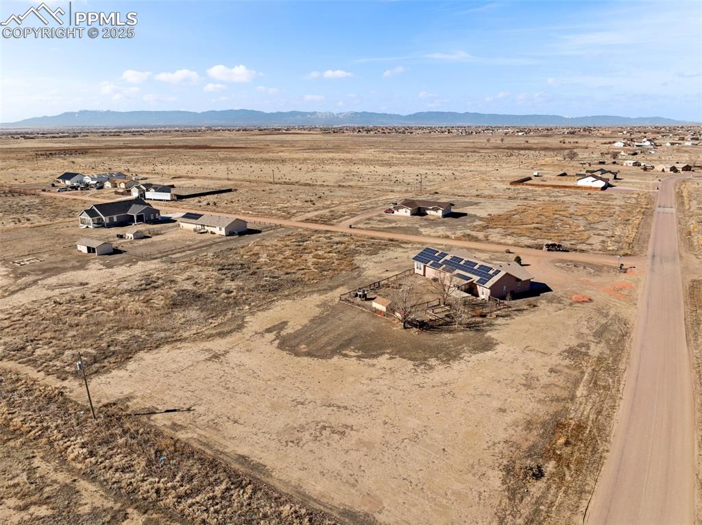 Image 9 of 9: View of rural area with a desert landscape and a mountain backdrop