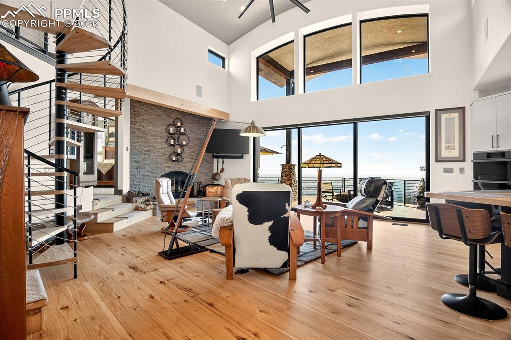 Image 10 of 50: Open concept living room with a glass pocketed door to back deck, wood burn