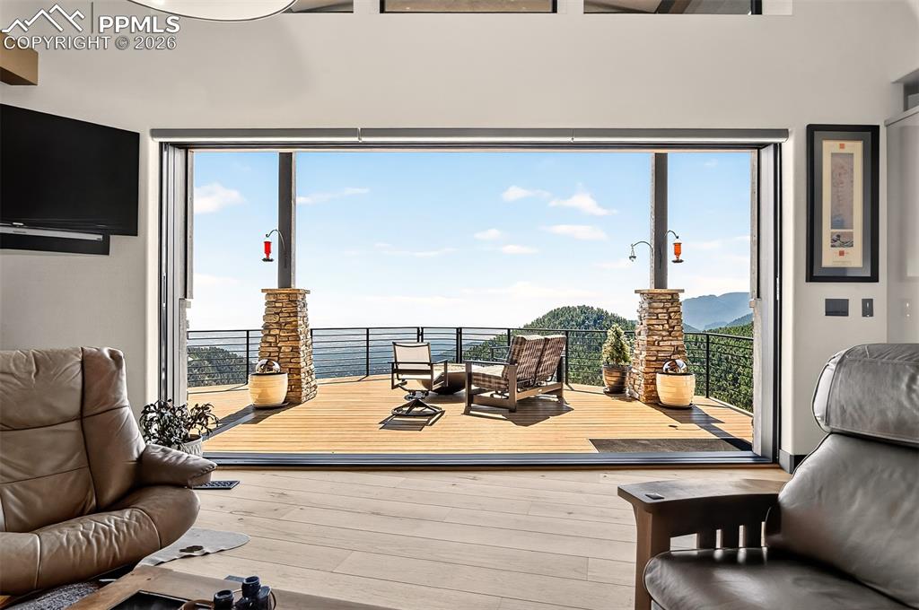 Image 15 of 50: Grand living room with a glass pocketed door which flows effortlessly to th