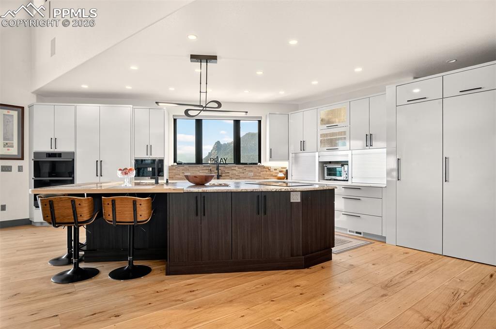 Image 23 of 50: Kitchen with large island, caressed granite countertops, black sandstone si