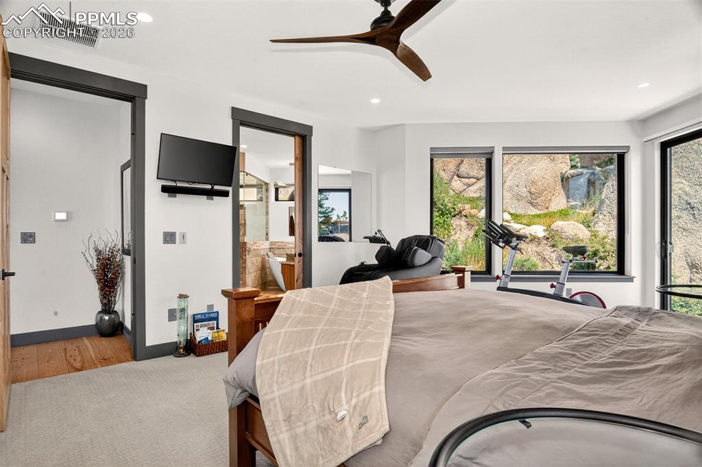 Image 30 of 50: Primary bedroom with en suite bath and a walk out to private patio