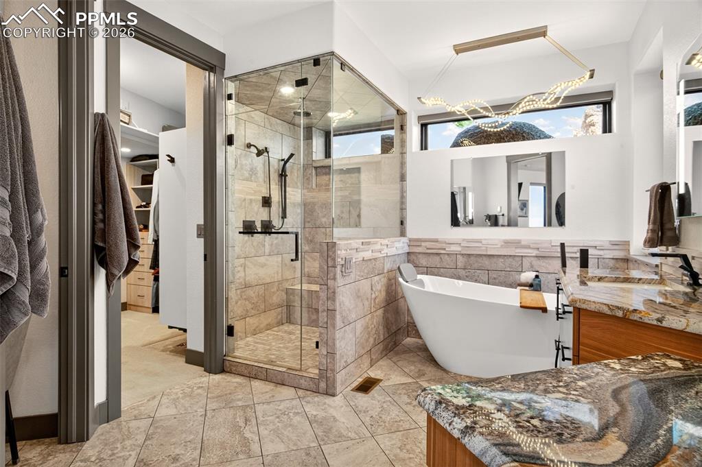 Image 31 of 50: 5 piece en suite primary bathroom with custom glass encased steam shower an