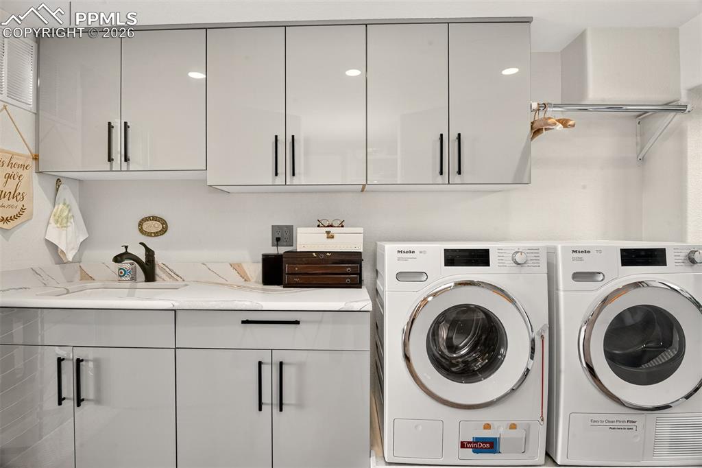 Image 35 of 50: Laundry room off the primary bedroom with utility sink and storage space
