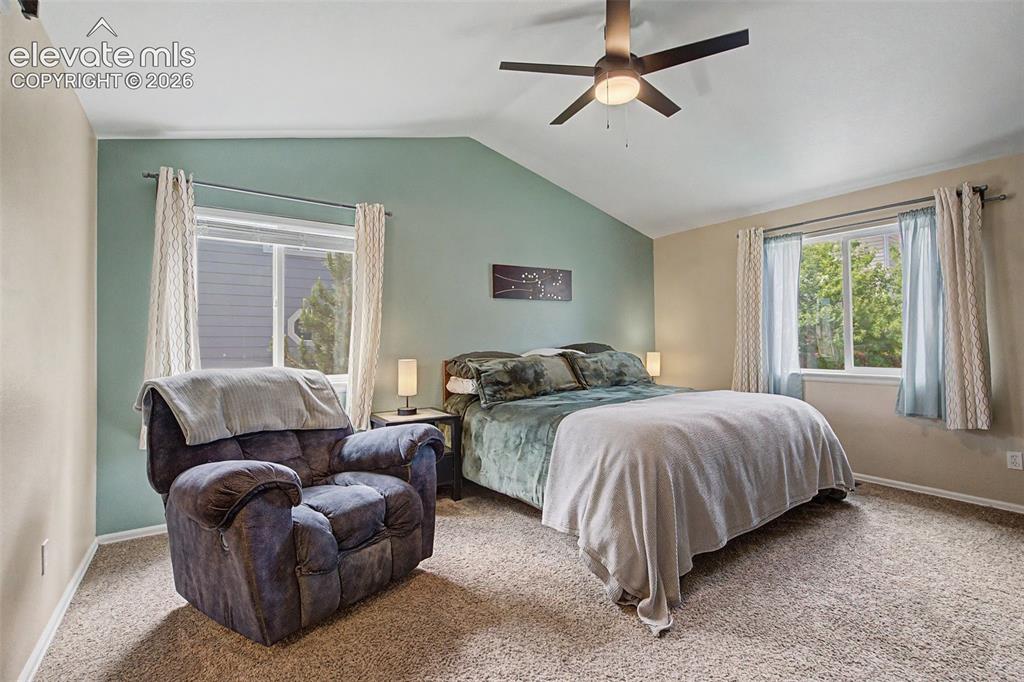 Image 16 of 39: Retreat to the spacious primary suite, featuring a vaulted ceiling, ensuite
