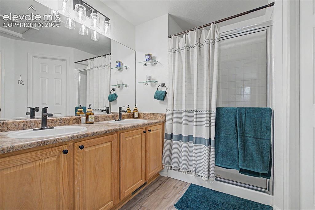Image 18 of 39: Primary bathroom featuring a double vanity, walk-in closet, and upgraded fl