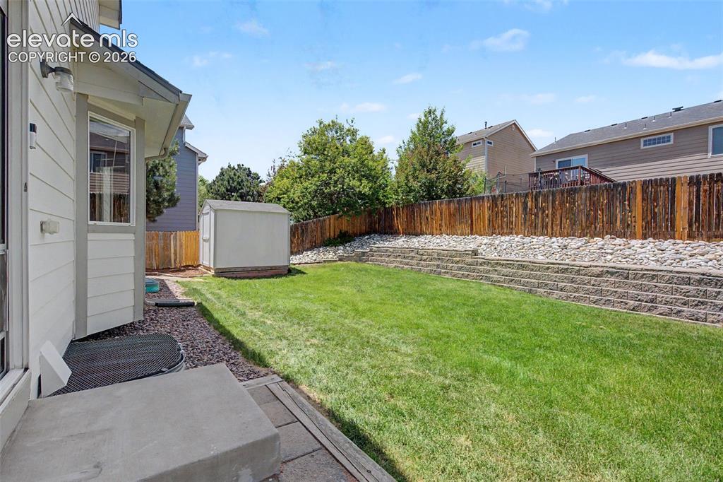 Image 31 of 39: Beautifully maintained backyard, featuring lots of space to play, relax, or