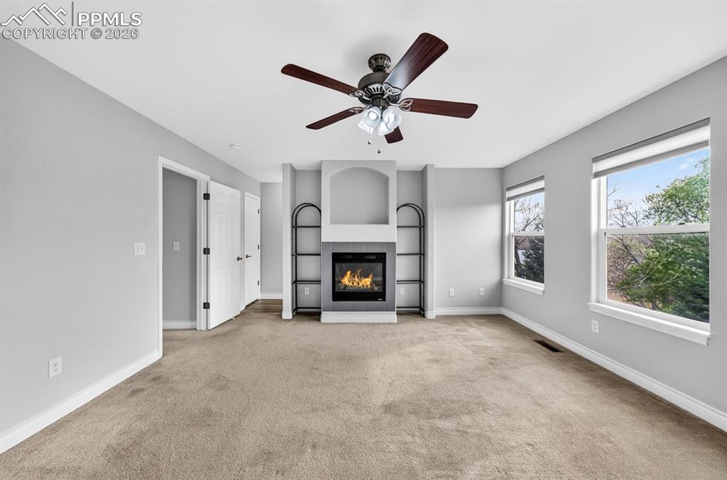 Image 7 of 21: Primary bedroom with gas fireplace