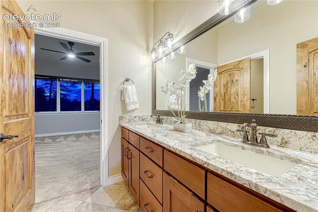 Image 32 of 48: Adjoining bathroom on the lower level, featuring new counters and lighting