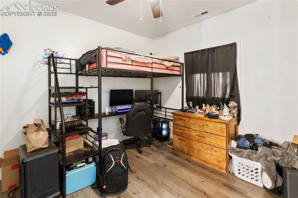 Image 16 of 34: The second bedroom has light wood-style flooring and a ceiling fan!