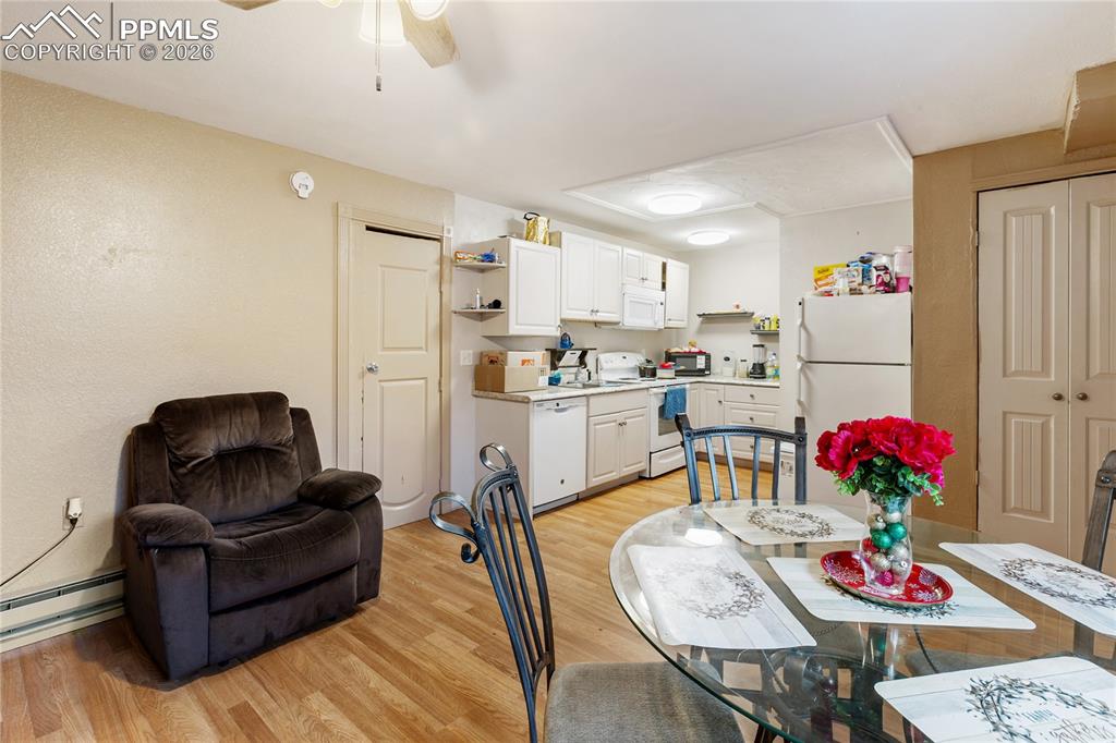 Image 25 of 34: The dining area features light wood-style floors and a ceiling fan, overloo