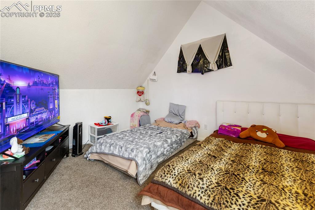 Image 28 of 34: The main bedroom with carpet floors and lofted ceiling!