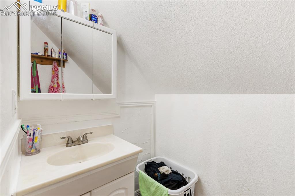 Image 33 of 34: Bathroom with vanity and a textured wall