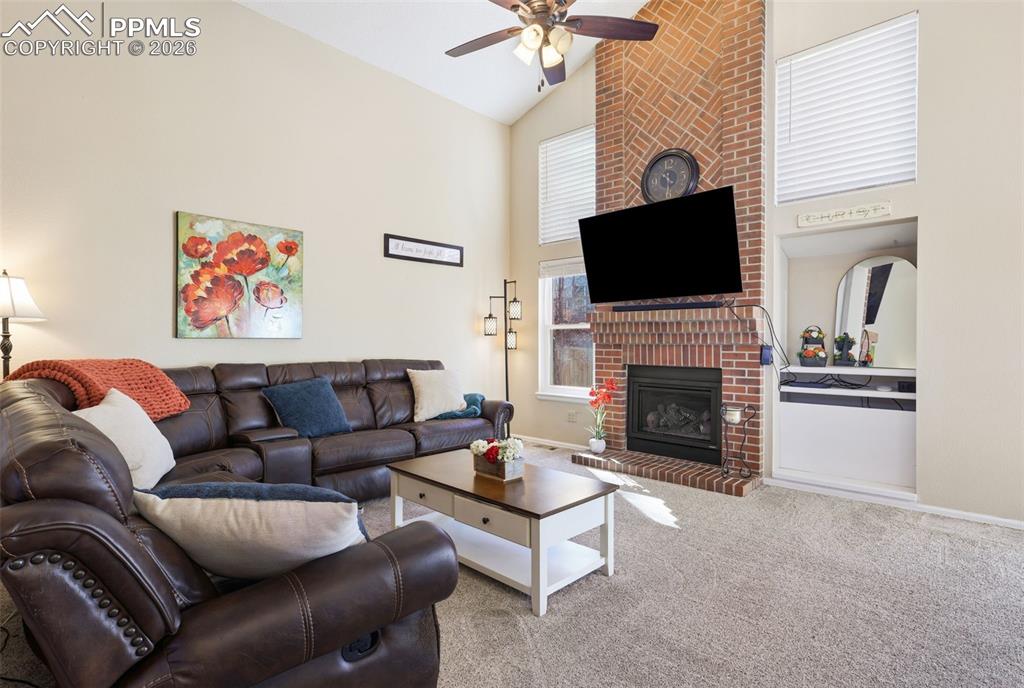 Image 7 of 29: Family room featuring brick fireplace and vaulted ceiling