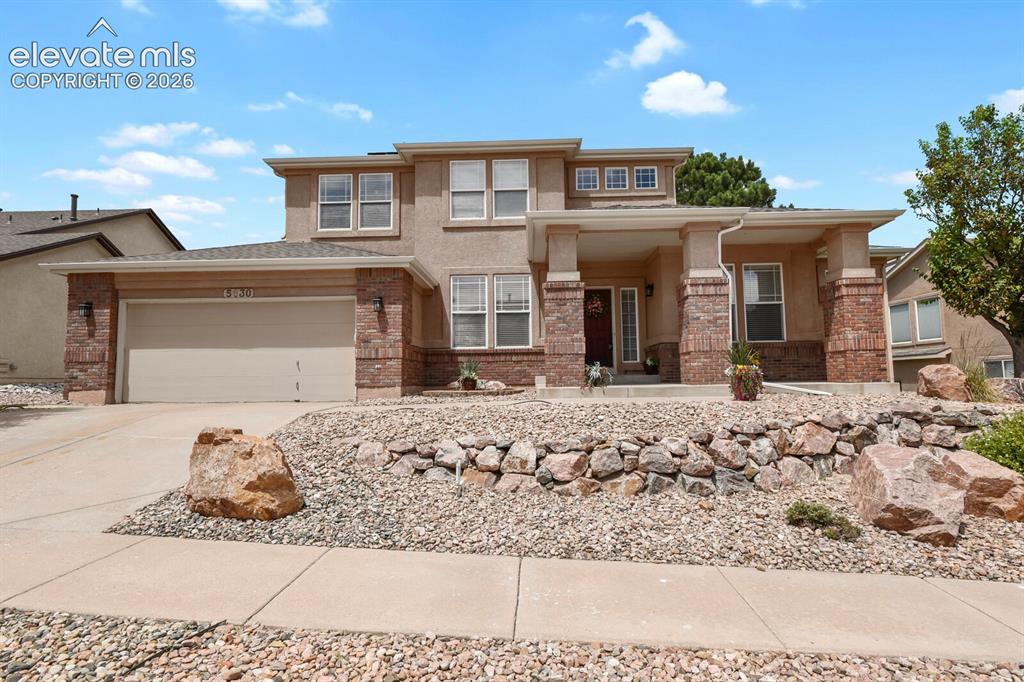 Image 1 of 50: Stucco and stone facade with a covered entry