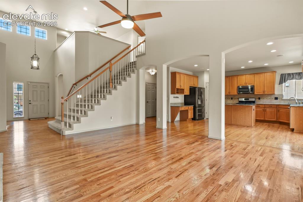 Image 14 of 50: Two-story entryway featuring wood-finish flooring, a grand staircase with w