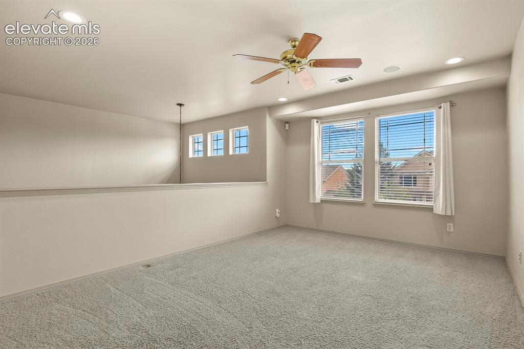 Image 22 of 50: Carpeted loft area featuring a ceiling fan, recessed lighting, and a partia