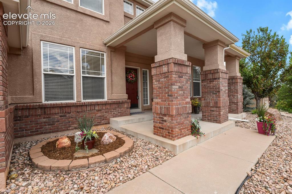 Image 4 of 50: Stucco exterior featuring a brick foundation and decorative brick columns s