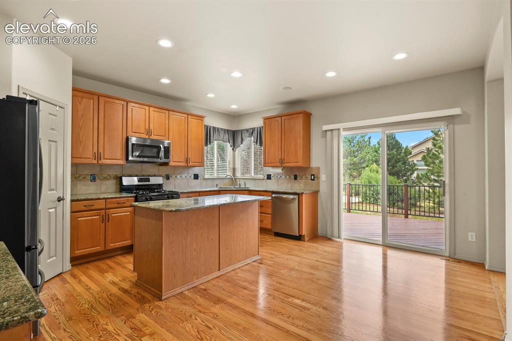 Image 8 of 50: Kitchen featuring wood-finish cabinetry, granite countertops, and stainless