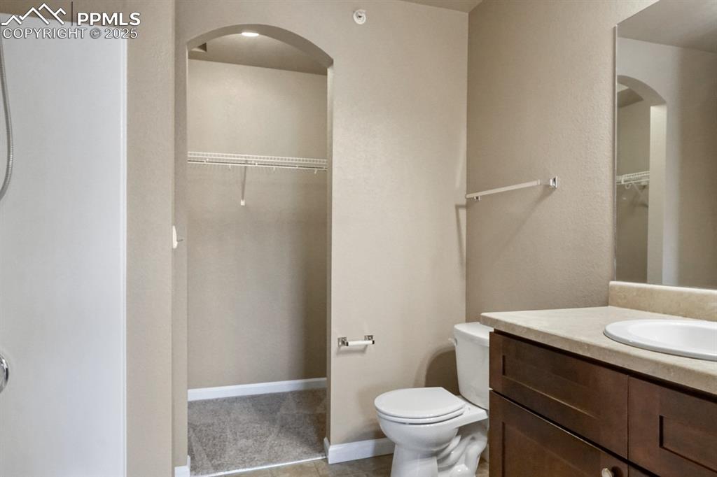 Image 14 of 18: Full bathroom with vanity and a walk in closet