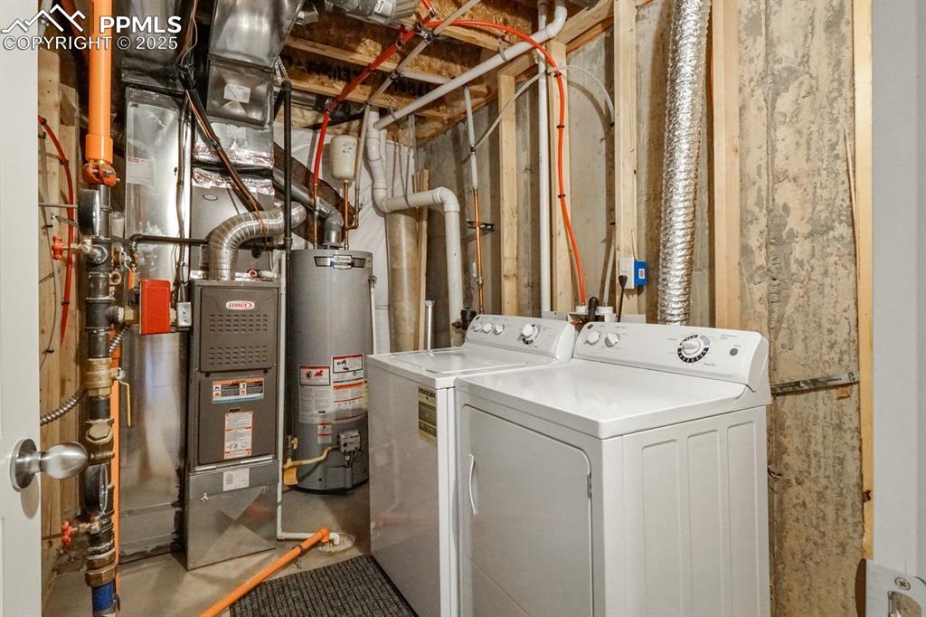 Image 9 of 18: Washroom with water heater and independent washer and dryer