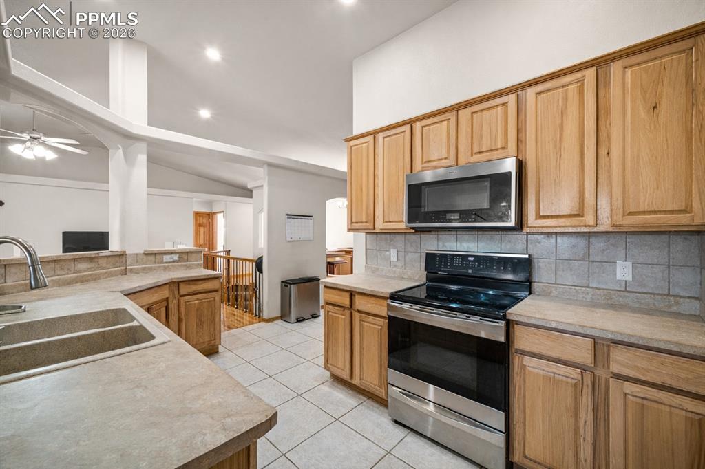 Image 25 of 46: Kitchen with stainless steel appliances and tile