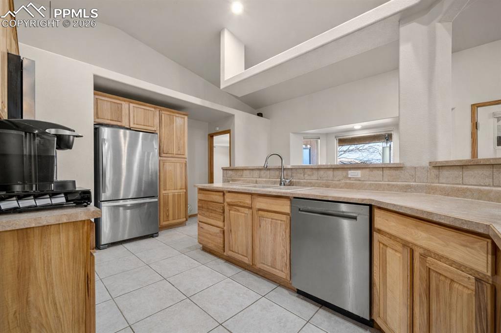Image 26 of 46: Kitchen with stainless steel appliances and tile