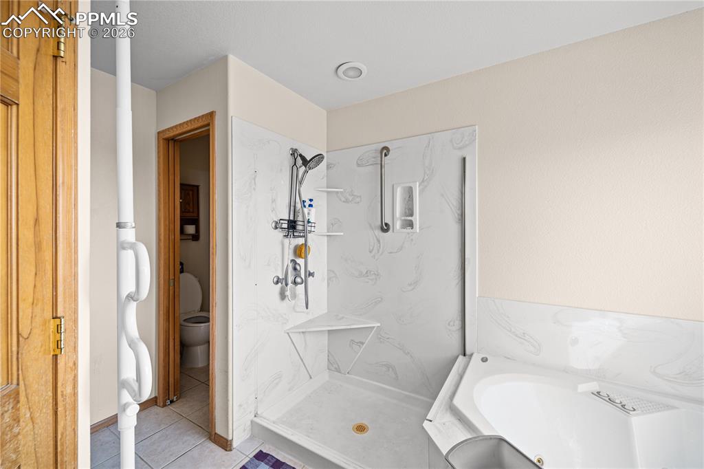 Image 31 of 46: Bathroom jetted tub with separate shower