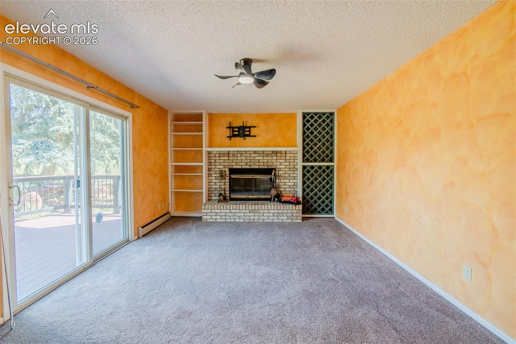 Image 16 of 47: Brick fireplace with hearth, built-in shelving, built-in wine rack, ceiling