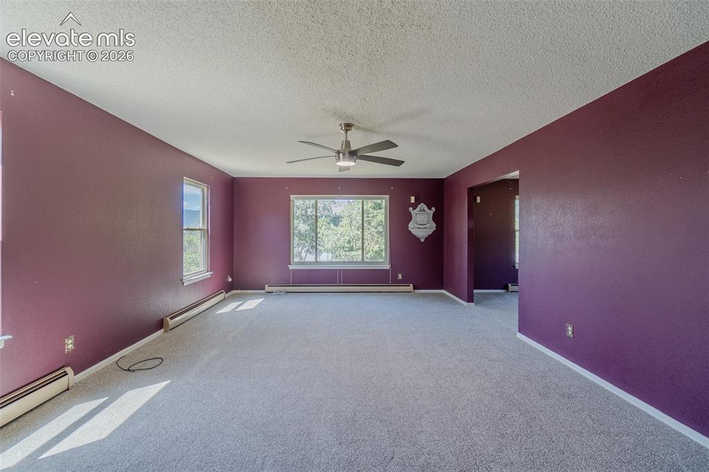 Image 18 of 47: Expansive room with neutral carpeting, multiple windows providing natural l