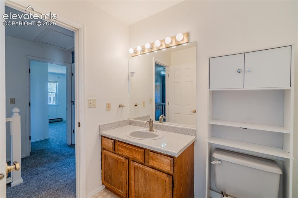 Image 28 of 47: Hall bathroom with Vanity with wood-finish cabinetry, integrated sink, and