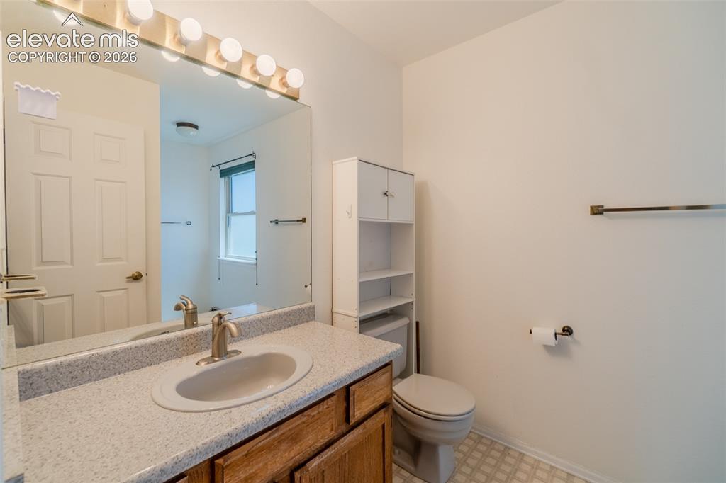 Image 30 of 47: Vanity with a single basin sink, speckled countertop, and wood-finish cabin