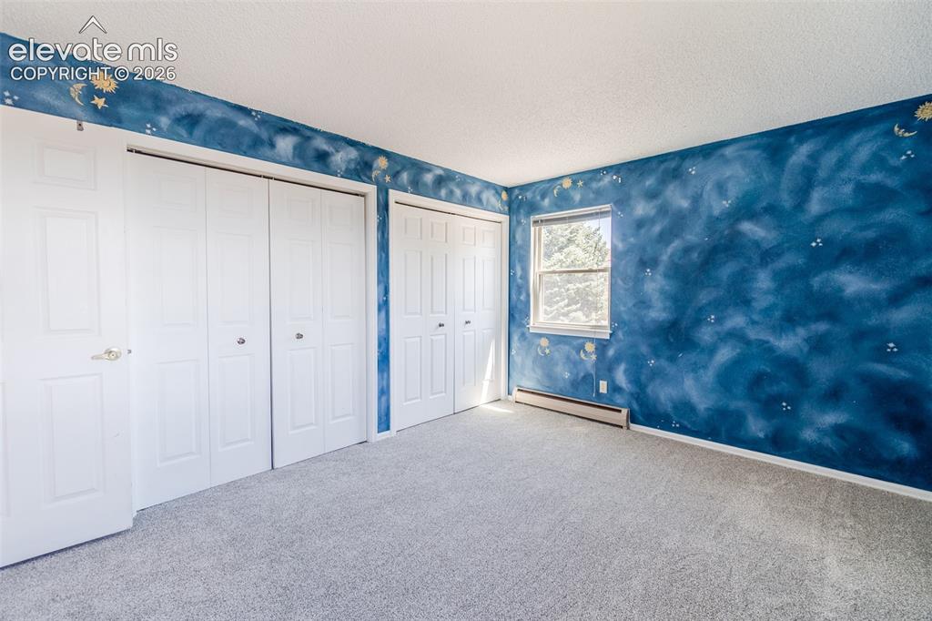 Image 33 of 47: Two of Four upstairs bedroom with new Carpet multiple white bi-fold closet 